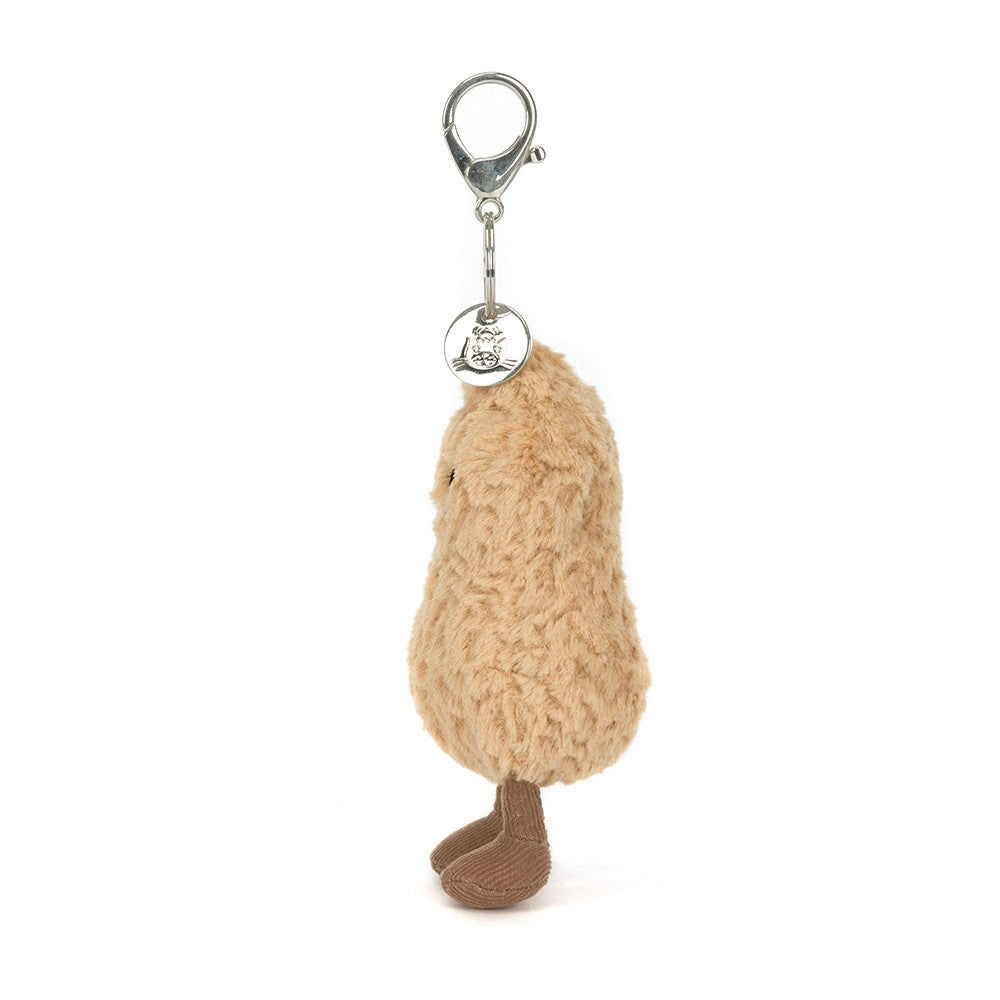 Side view of Jellycat Amuseables Peanut Bag Charm Plush keychain in the shape of a peanut with a smiling face on a white background