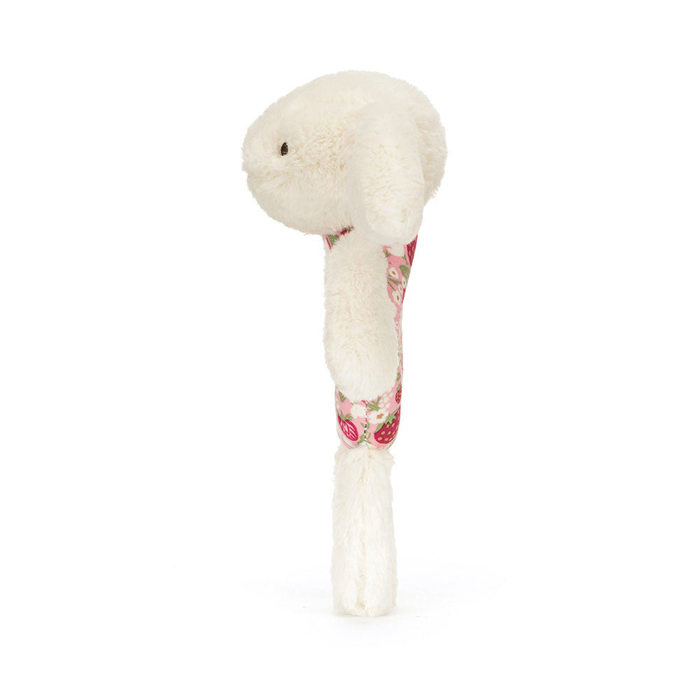 White plush toy with floral patterned handle on a white background