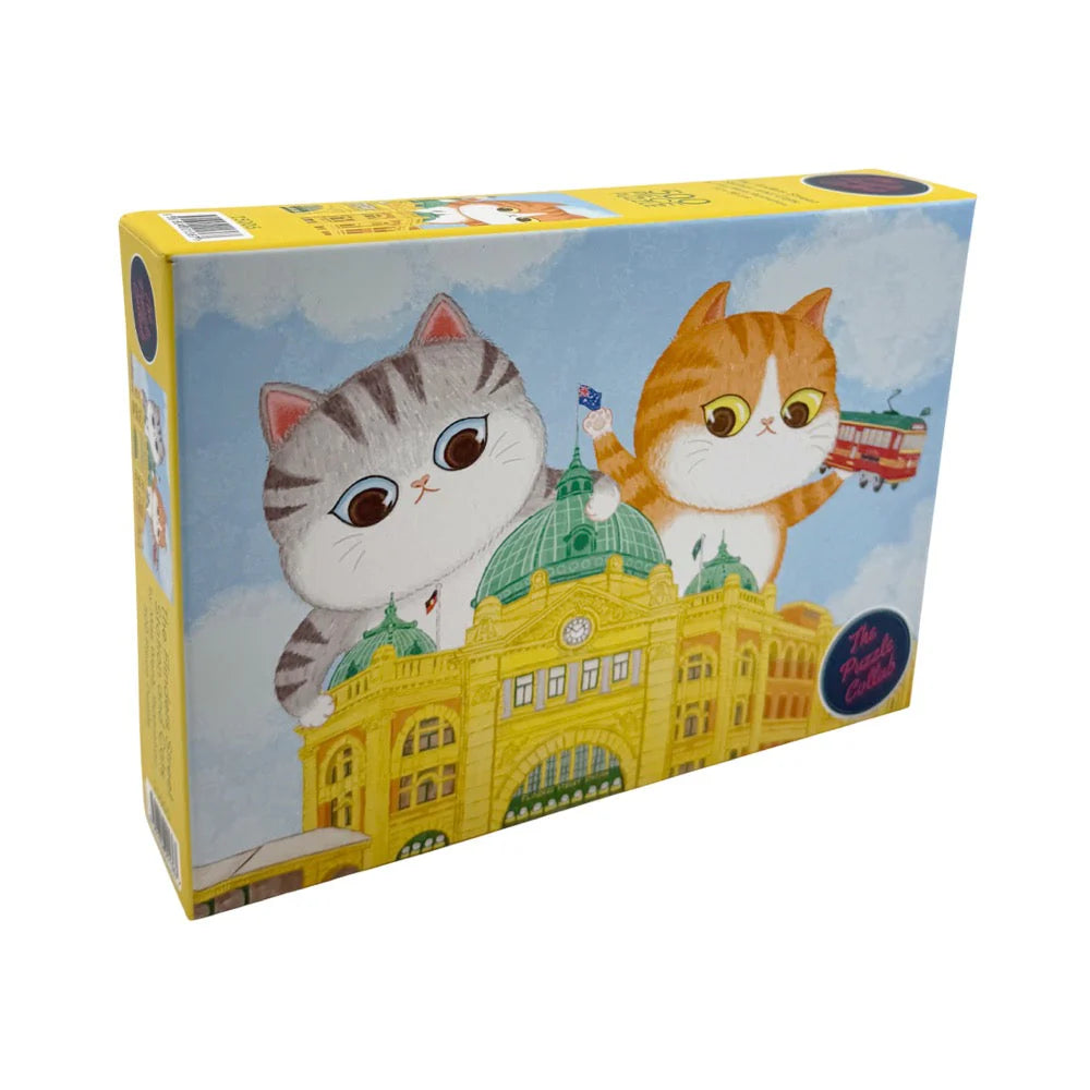 Puzzle Collab Jigsaw Puzzle Product packaging with cartoon cats on Flinders Street Station building, on a white background.