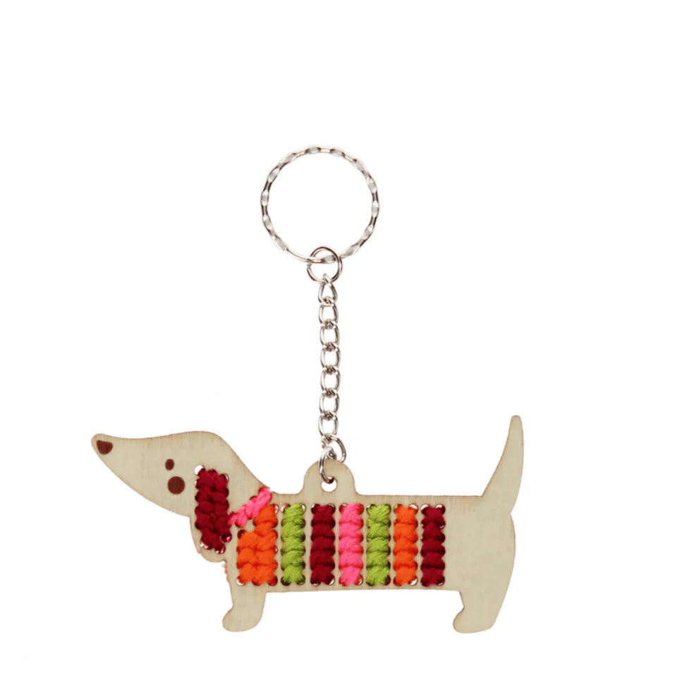 Rex London Keychain in the shape of a dog with a colorful striped sweater on a white background