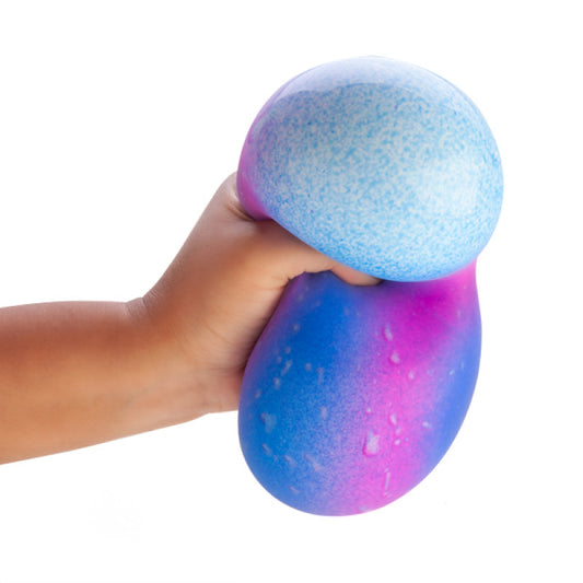 Hand holding a Smooshos Jumbo Galaxy ball a blue and purple stress ball against a white background