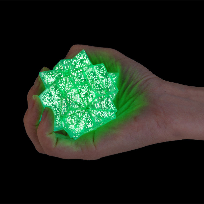 Smooshos Super Squeeze Glow in the Dark Starburst green glowing object against a black background