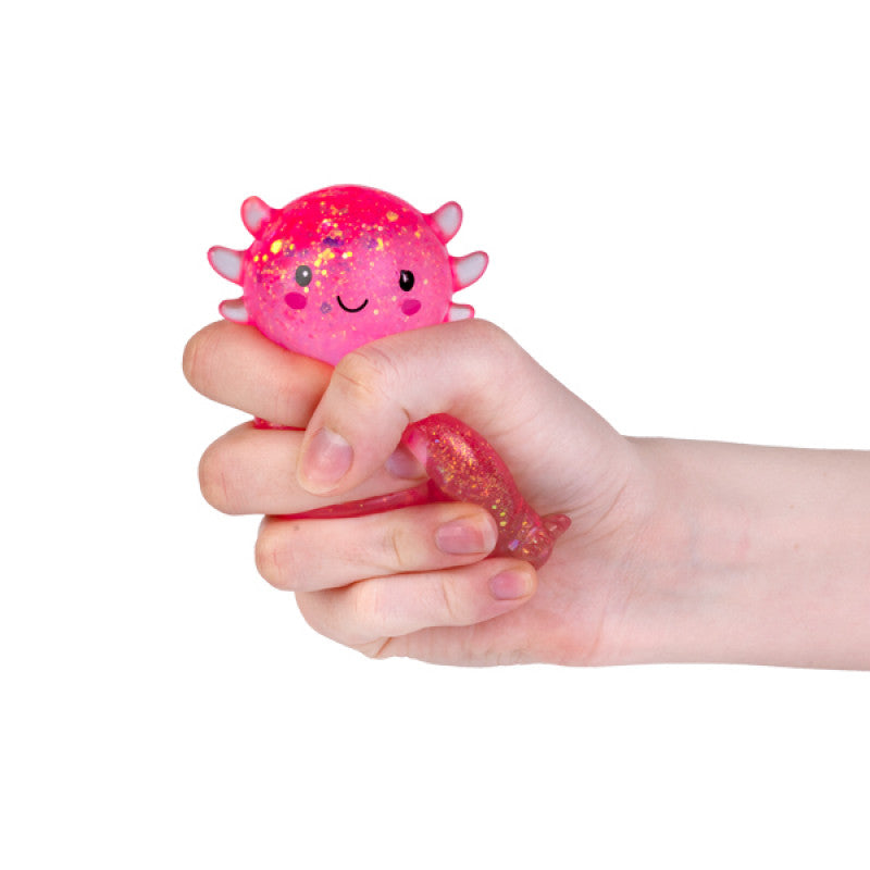 Pink Smooshos Super Squeeze Glitter Axolotl held in a hand on a white background