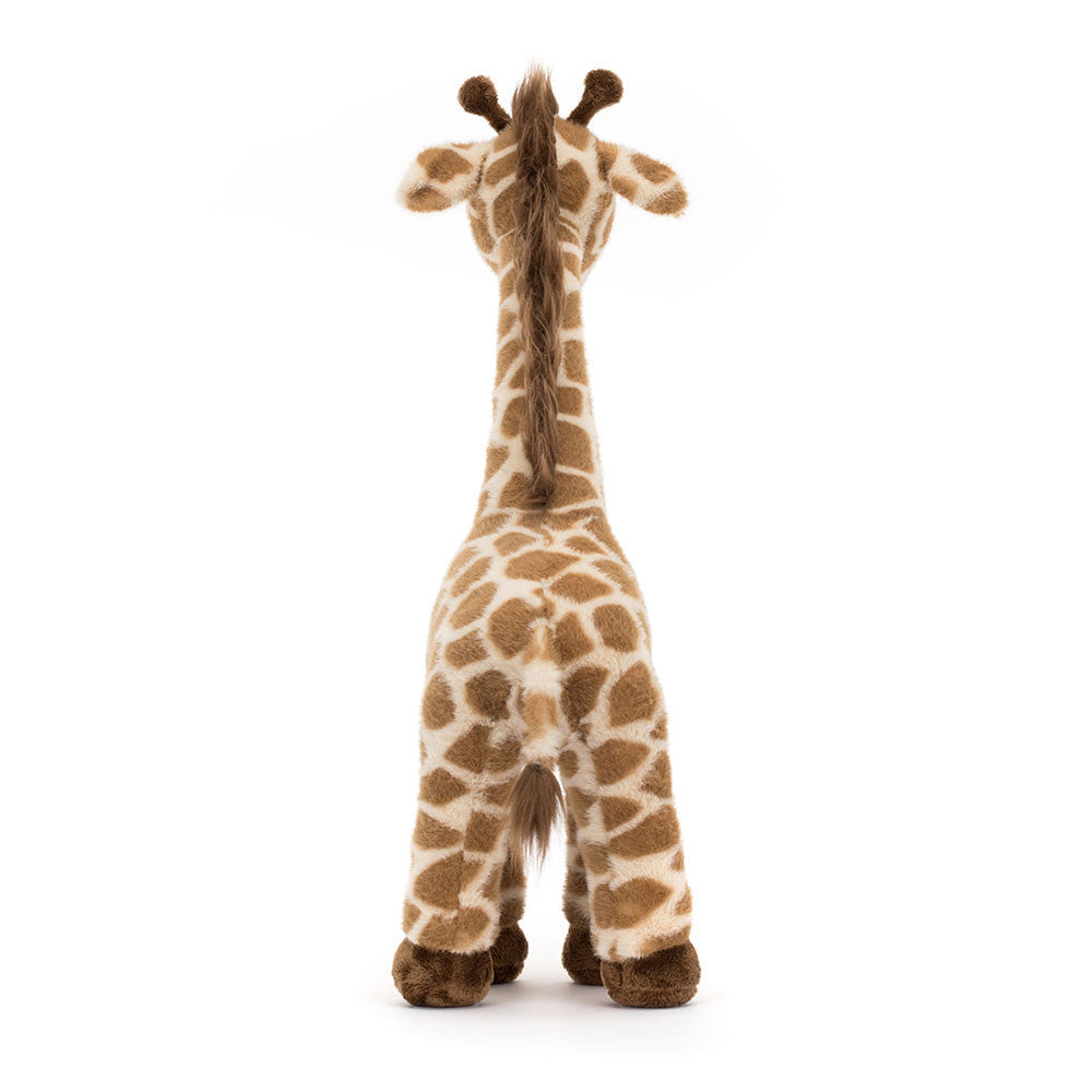 Jellycat Dara Giraffe plush toy from Plato’s, shown from the back, featuring soft patterned fur, long legs, and a sweet smiling face.