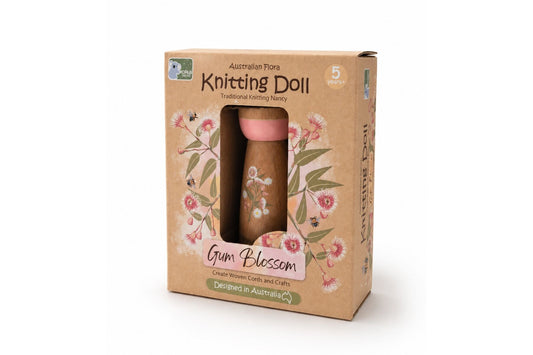 Knitting doll in a cardboard box with floral design on a white background